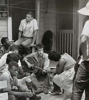 Dylan, with guitar, in the early 1960s somewhere in the south -- quite possibly Greenwood, MS, July 1963.  Photo, www.bobdylan.com