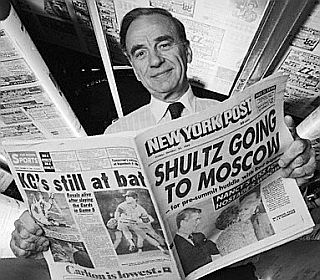 Rupert Murdoch in the New York Post press room with a copy of a Ronald-Reagan era edition of the paper, 1980s.