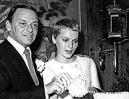 Frank Sinatra and Mia Farrow cutting their wedding cake, July 1966.