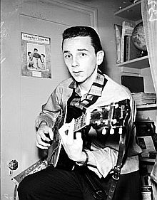 Young Phil Spector with Teddy Bears photo behind him, 1958.
