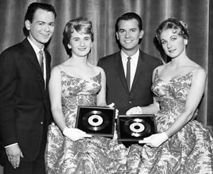 1959: The Fleetwoods with American Bandstand's Dick Clark, receiving gold records for “Come Softly to Me” and “Mr. Blue.”
