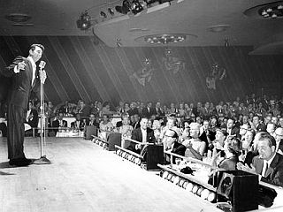 Dean Martin on stage at the Sands in Las Vegas, where Rat Pack performances drew large crowds of celebrities & VIPs from Hollywood and elsewhere.