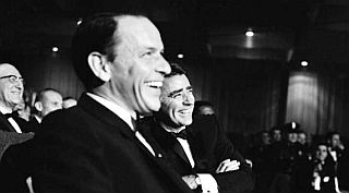 Frank Sinatra & Peter Lawford enjoy a lighter moment at the 1961 gala for President-elect John F. Kennedy.