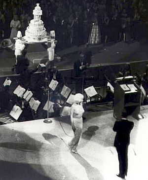 JFK birthday cake being carried into hall as Monroe & Lawford leave stage.  Photo, Life/Bill Ray. 
