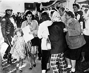 Nov 30, 1960: White parent Mrs. James Gabrielle, with police escort, is harassed by protestors as she walks her young daughter home after day in the newly integrated William Frantz school in New Orleans. Crowd wanted total white boycott. AP photo.