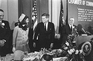 Jackie Kennedy at the head table between JFK and Lyndon Johnson, left, and official of the Fort Worth Chamber of Commerce, at the podium.