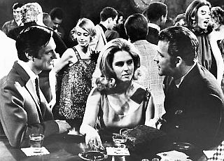 1968: Alan Alda, left, visits with Maxine and Frank Gifford, right, in a scene from the film, “Paper Lion.” Click for DVD.