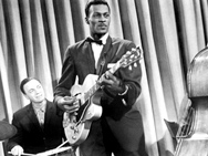 Screen shot from "Go, Johnny Go!" shows Alan Freed on drums behind Chuck Berry on guitar.