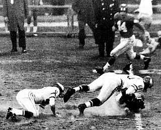 Chuck Bednarik continuing through his tackle of Frank Gifford as Gifford hits the ground.