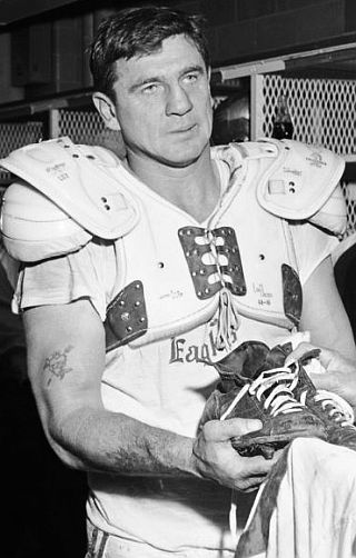 Chuck Bednarik, age 37, handing in his spikes and jersey for team history after his final Eagles game, November 1962.