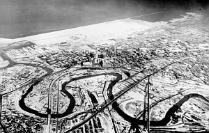 December 1937: Aerial view of meandering Cuyahoga River in winter snow wending its way toward Lake Erie at Cleveland, Ohio. photo, National Archives.