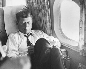 JFK in a private moment aboard his campaign plane, The Caroline, which logged thousands of miles during the primary and general election campaigns.