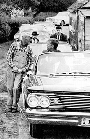 September 22, 1960: JFK, in backseat of Pontiac convertible, talks with farmer James Cox during a visit to his farm in Fort Dodge, Iowa. AP photo.