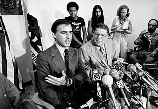 July 19, 1978: California Gov. Jerry Brown makes a point at news conference in Los Angeles during his reelection bid as tax reformer Howard Jarvis and reporters look on. AP photo.