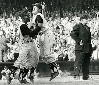 Roberto Clemente, with Dick Groat behind him, gives Hal Smith a celebratory lift for hitting a 3-run home run giving the Pirates a 9-to-7 lead over the NY Yankees in the bottom of 8th inning, Game 7, 1960 World Series. Click for autographed photo.
