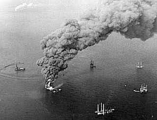 December 1970: Smoke & flames rise from Shell Oil's burning rig in the Gulf of Mexico, as five mobile rigs around it work to drill relief wells. Photo: Times-Picayune, New Orleans.