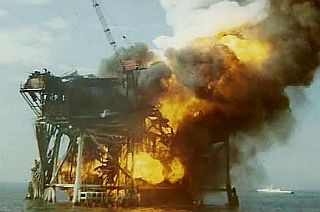 December 1970: Bob King photo of Shell offshore platform blaze captures the beginning collapse of the rig.