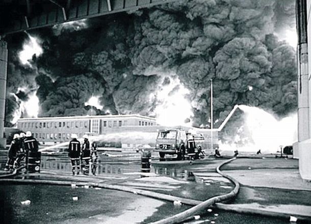 August 17, 1975: Firemen and equipment beneath Penrose Bridge as they move in to fight the Gulf Oil refinery blaze in Philadelphia, PA, with a Gulf Oil office building in the fire’s path.