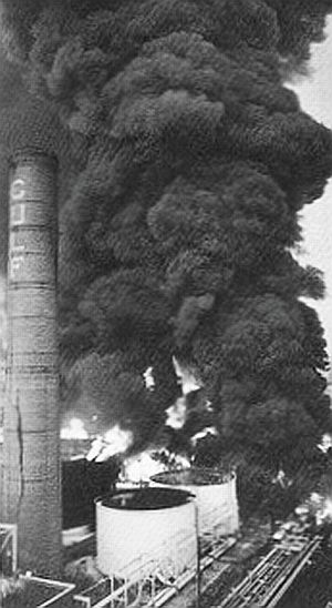 Another view of the August 1975 Gulf Oil refinery fire in Philadelphia, PA with the former landmark brick boiler stack, ruined in the blaze.