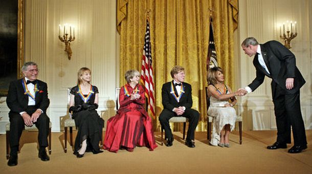 President George W. Bush congratulates Tina Turner during a reception for the Kennedy Center Honors in the East Room of the White House Sunday, December 4, 2005. From left, the honorees are: singer Tony Bennett, dancer Suzanne Farrell, actress Julie Harris, actor Robert Redford, and singer Tina Turner. White House photo, Eric Draper.