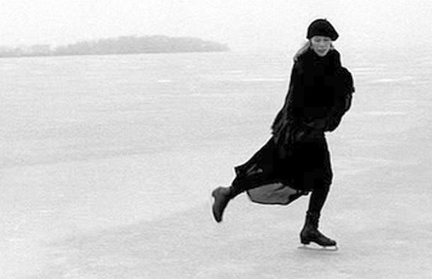 Joni Mitchell skating on frozen Lake Mendota, near Madison, Wisconsin, 'Picnic Point' behind her, March 1976. Photo, Joel Bernstein. Also used on her 'Songs of a Prairie Girl' album (2005). Click for album.