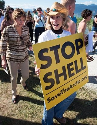 2015.  Jane Fonda holding a 'Stop Shell' protest sign at an anti-oil development gathering in Vancouver, British Columbia. 