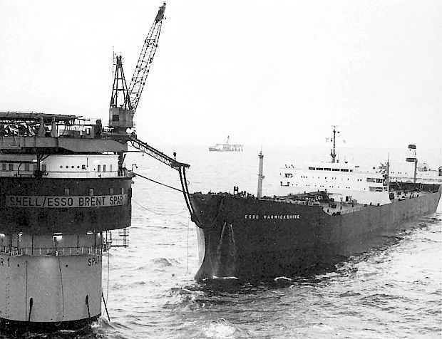Photo showing large oil tanker, the “Esso Warwickshire," taking on oil from the Brent Spar storage unit during its working years, likely sometime in the late 1970s or early 1980s.