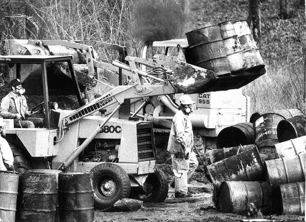 Workers at the A.L. Taylor / Valley of the Drums site with protective respirators moving chemical drums in March 1979 to protect a small stream from contamination at the toxic-waste site. Source: The Courier-Journal.