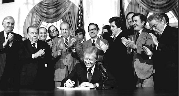 December 11, 1980.  President Carter signing Superfund law at the White House. Among those attending in the first row behind Carter are, L-to-R: Sen. Daniel Patrick Moynihan (D-NY), Sen. Jennings Randolph (D-WV), Sen. Robert Stafford (R-VT), Sen. George Mitchell (D-ME), Rep. James Florio (D-NJ) [Sen. Bill Bradley (D-NJ) behind Florio], Sen. John Chafee (D-RI), and others.