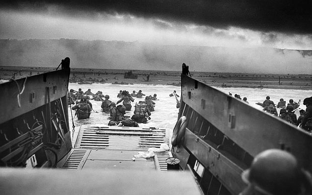 Cropped version of famous WWII photo titled, “Into the Jaws of Death,” taken on D-Day, June 6, 1944, by Robert F. Sargent, a chief photographers mate in the U.S. Coast Guard. It depicts soldiers from U.S. Army infantry divisions disembarking from landing craft and wading ashore at Omaha Beach.